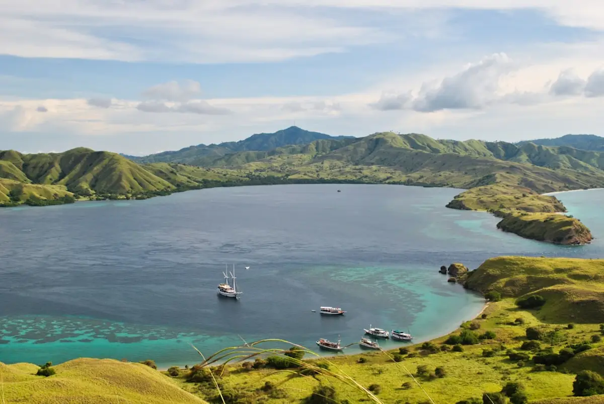 A traditional phinisi liveaboard anchored in calm Sumbawa waters